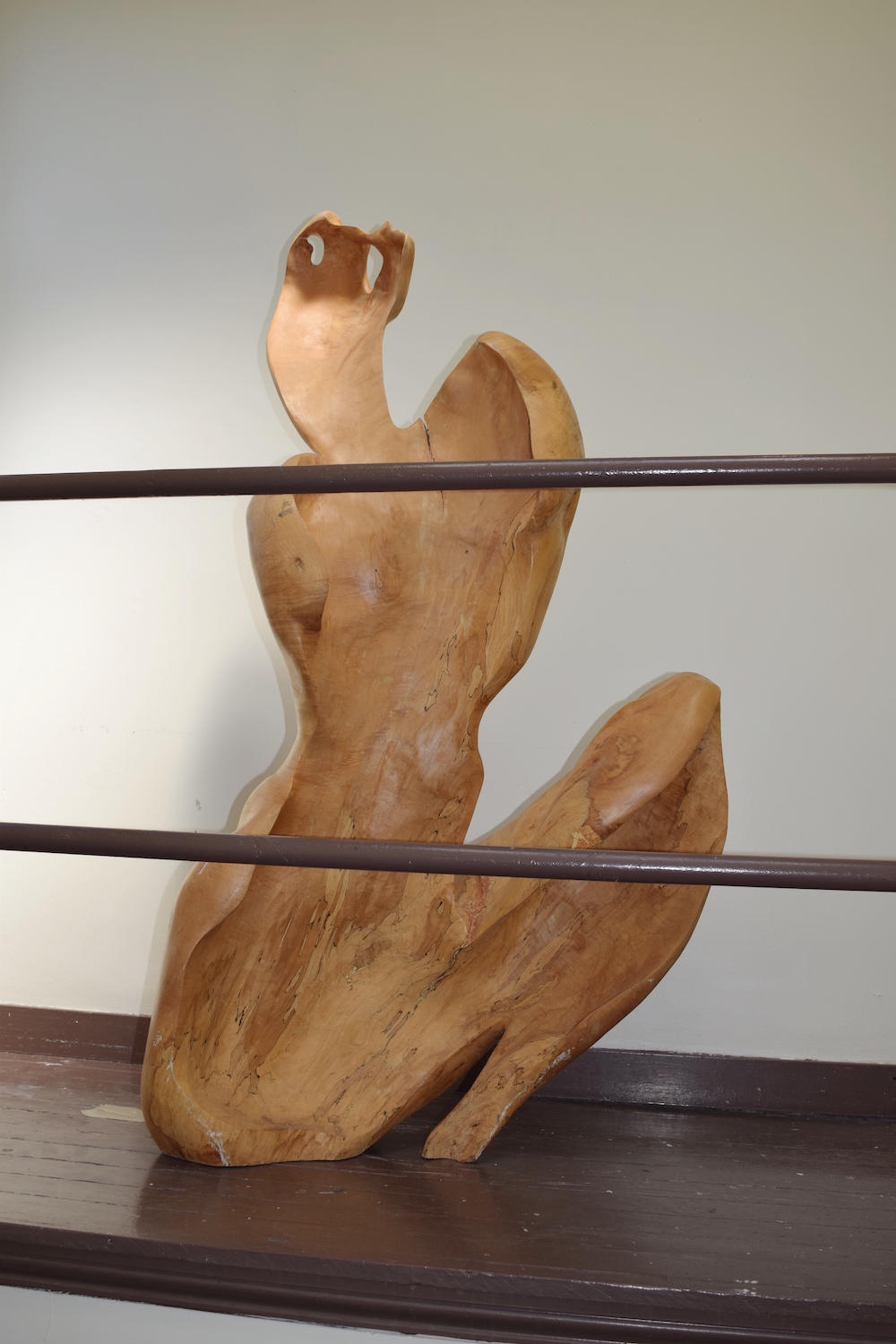 side shot of large wooden sculpture of abstract female form